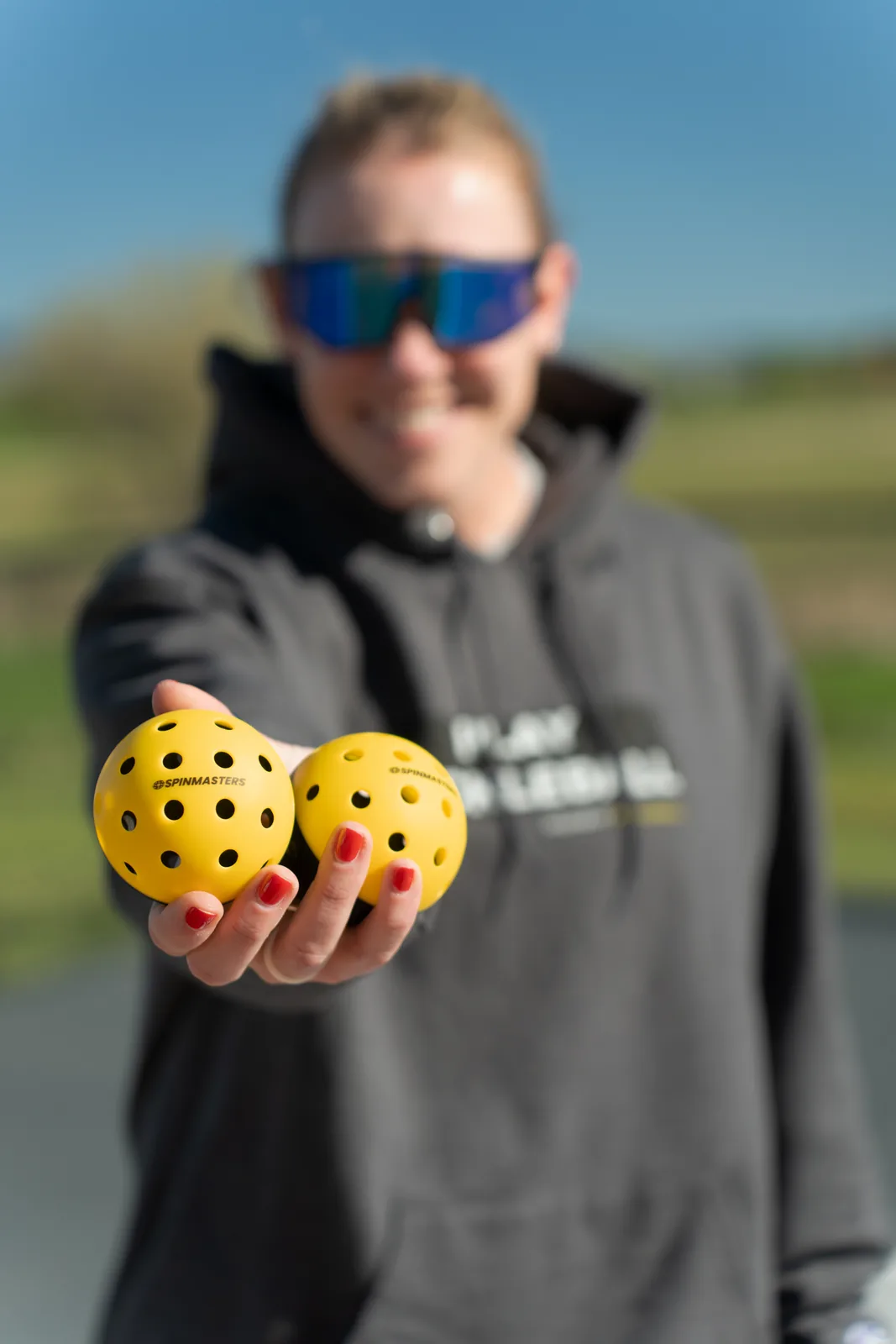 Player holding two Spinmasters training balls in one hand